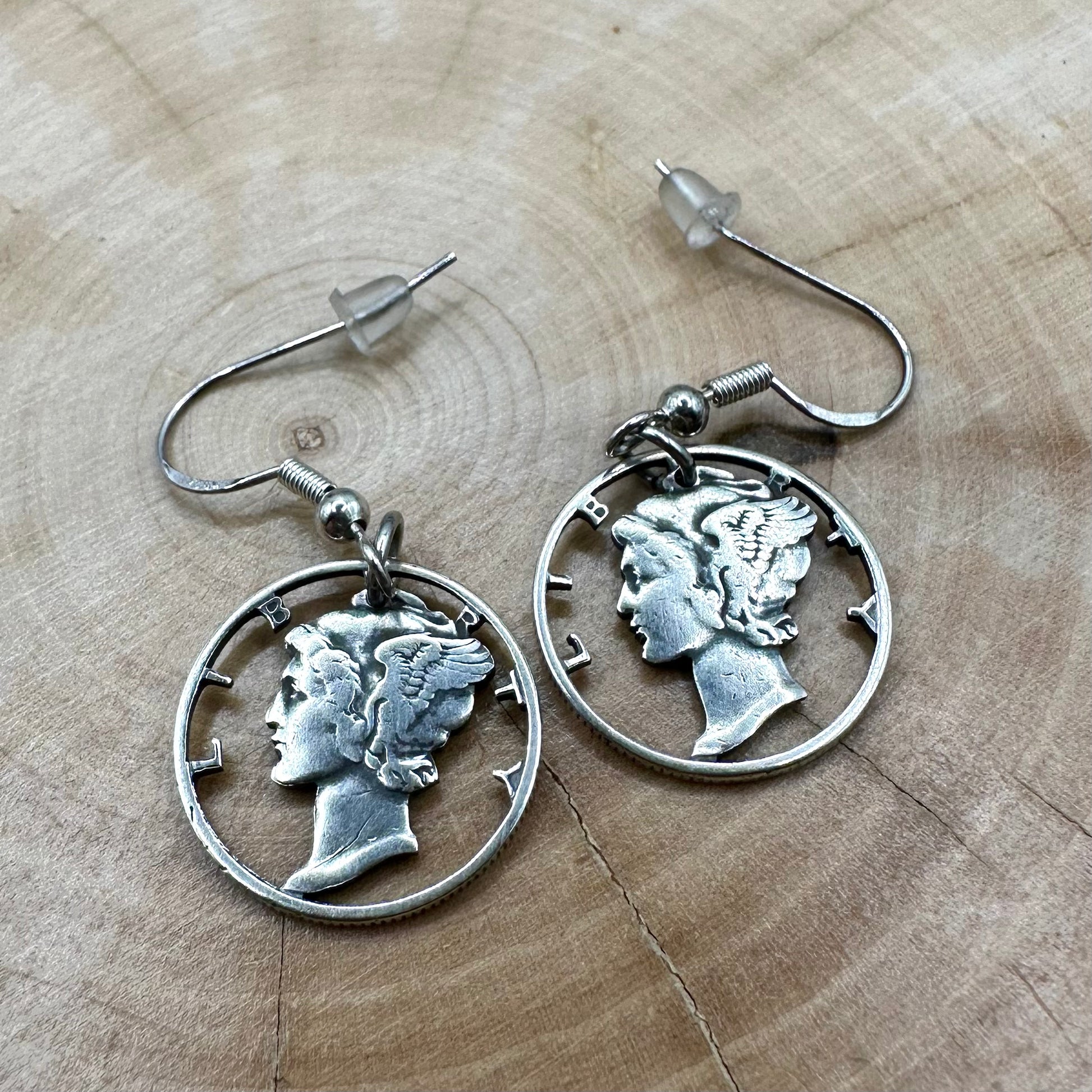 U.S. Mercury Dime Silver Hand Cut Coin Earrings on a light wood round. - Mountainstruck Coin Jewelry