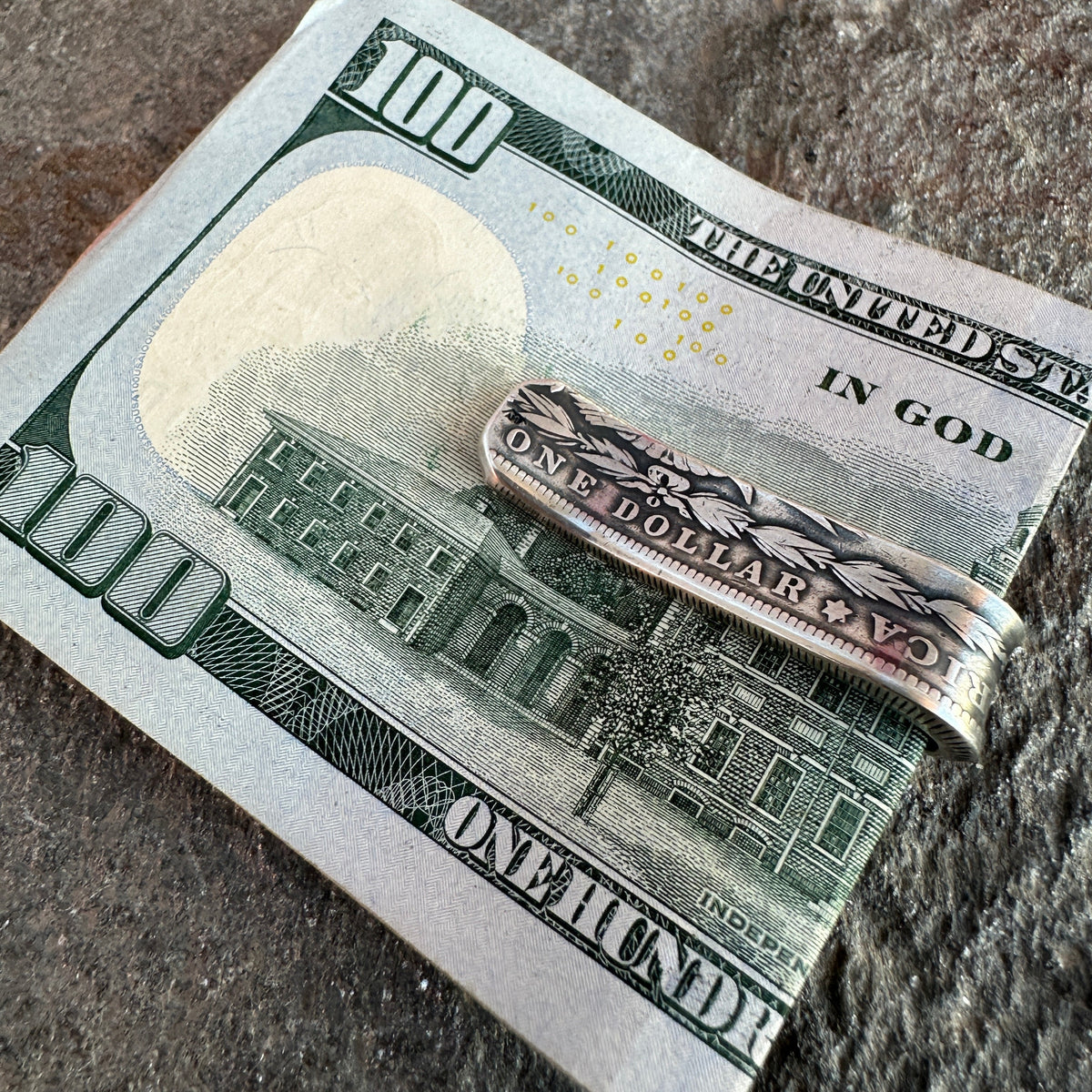 U.S. Morgan Dollar Silver Coin Money Clip holding money on a textured rock background.
- Mountainstruck Coin Jewelry