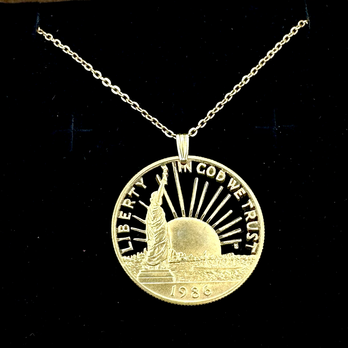 24k Plate U.S. Nation of Immigrants Cut Half Dollar Coin Necklace in a brown kraft box on a black velvet background. - Mountainstruck Coin Jewelry