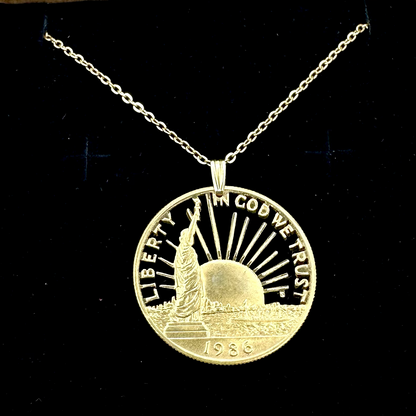 24k Plate U.S. Nation of Immigrants Cut Half Dollar Coin Necklace in a brown kraft box on a black velvet background. - Mountainstruck Coin Jewelry