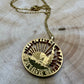 24k Plate U.S. Nation of Immigrants Half Dollar Hand Cut Coin Necklace on a light wood round. - Mountainstruck Coin Jewelry