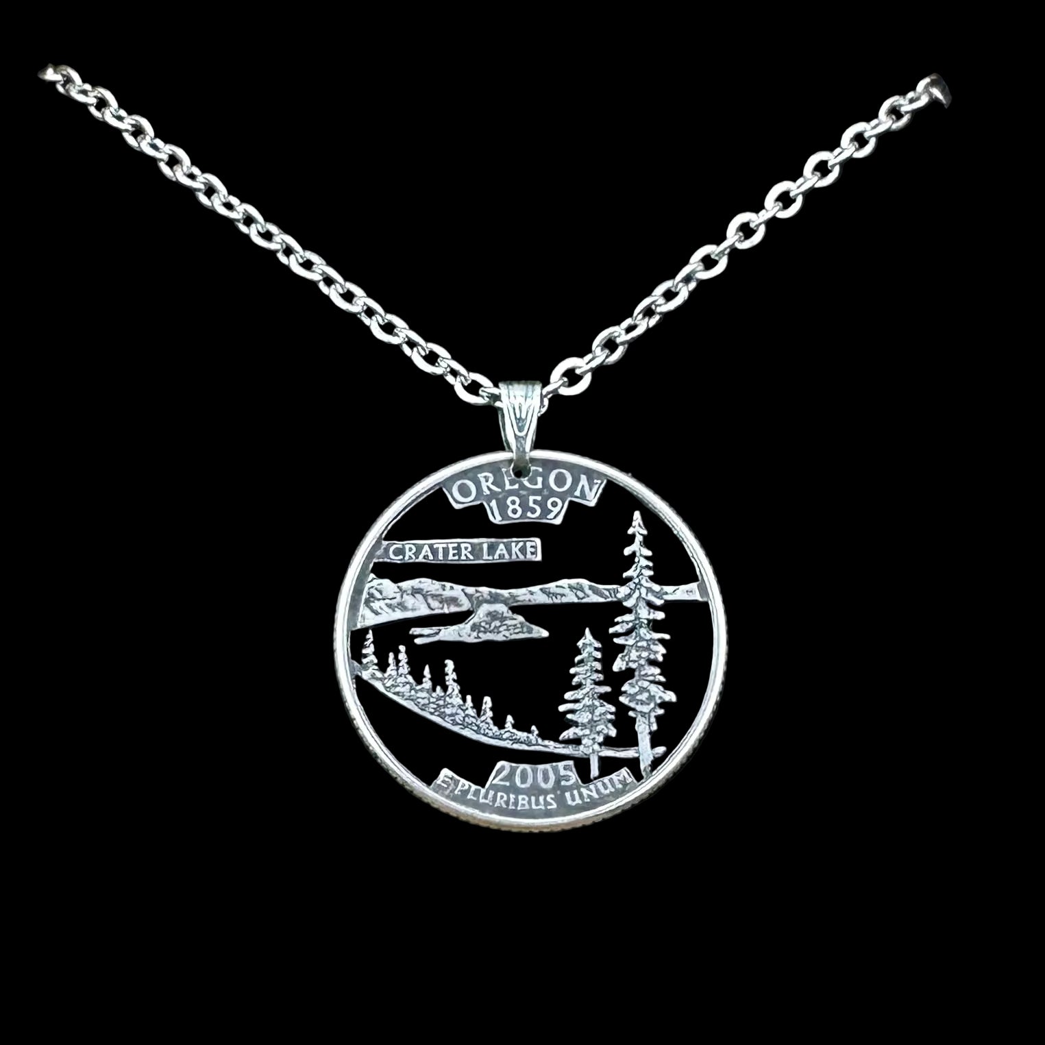 U.S. Oregon State Quarter Hand Cut Coin Necklace with a stainless chain on a black velvet background. - Mountainstruck Coin Jewelry