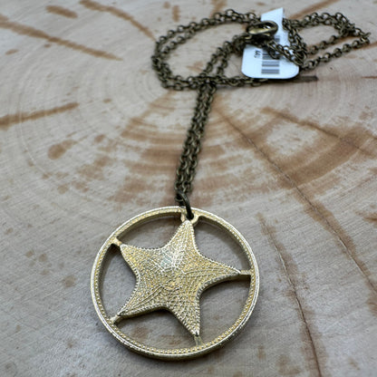 Bahamas 1 Cent Starfish hand cut coin necklace on a wood background. - Mountainstruck Coin Jewelry