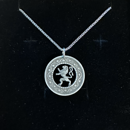 Belgium 10 Cents Lion hand cut coin necklace in a brown kraft box on a black velvet background. - Mountainstruck Coin Jewelry
