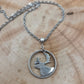 Canada Caribou 25 Cents hand cut coin necklace with a stainless steel chain on a wood background. - Mountainstruck Coin Jewelry