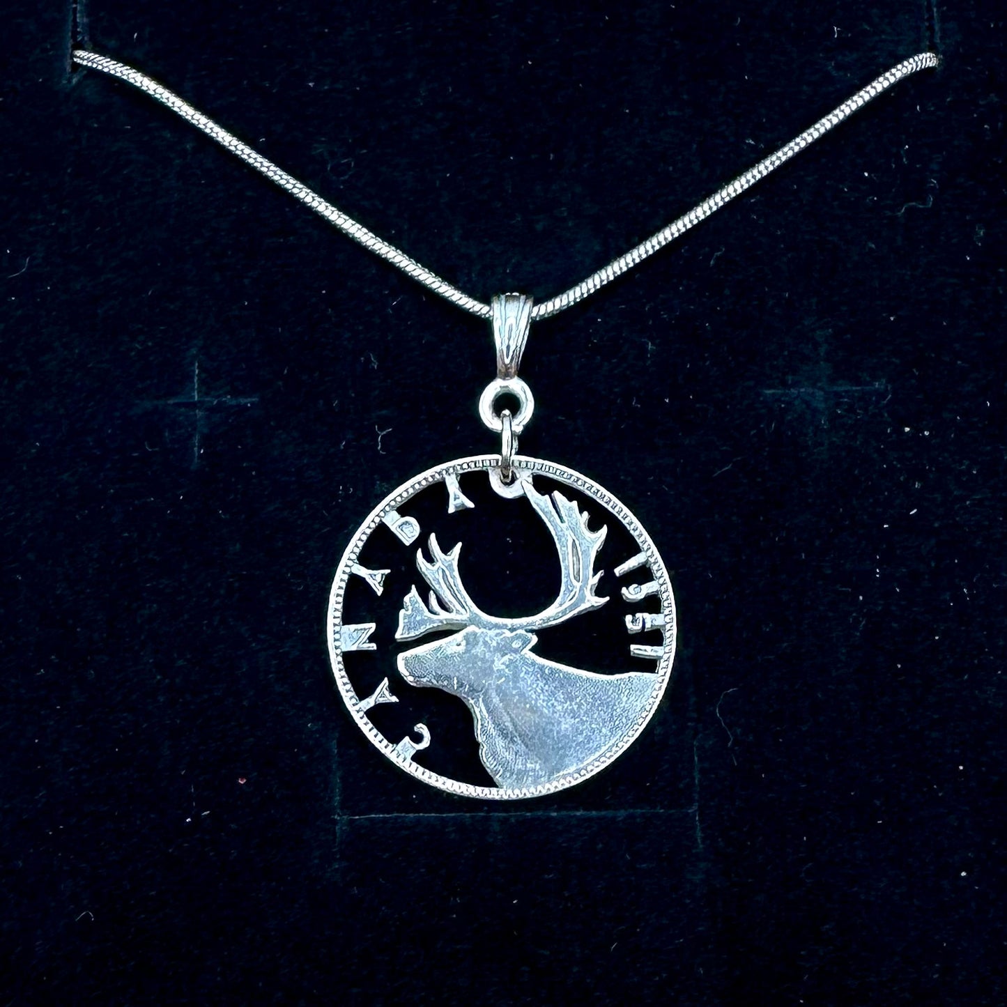 Caribou Canada Silver 25 Cent Hand Cut Coin Necklace on a black velvet  background. - Mountainstruck Coin Jewelry