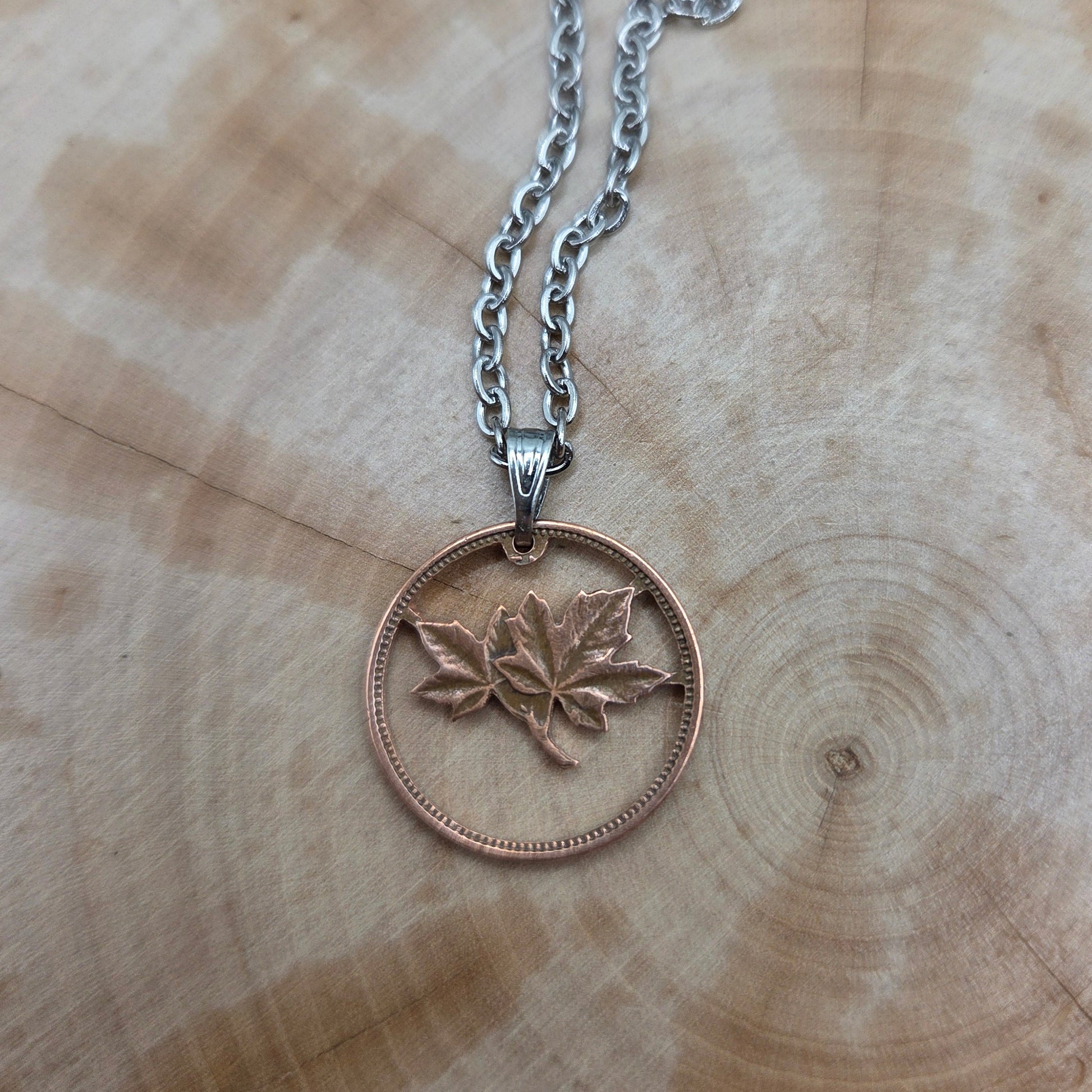 Canada Maple Leaf Penny Hand Cut Coin Necklace on a wood background. - Mountainstruck Coin Jewelry