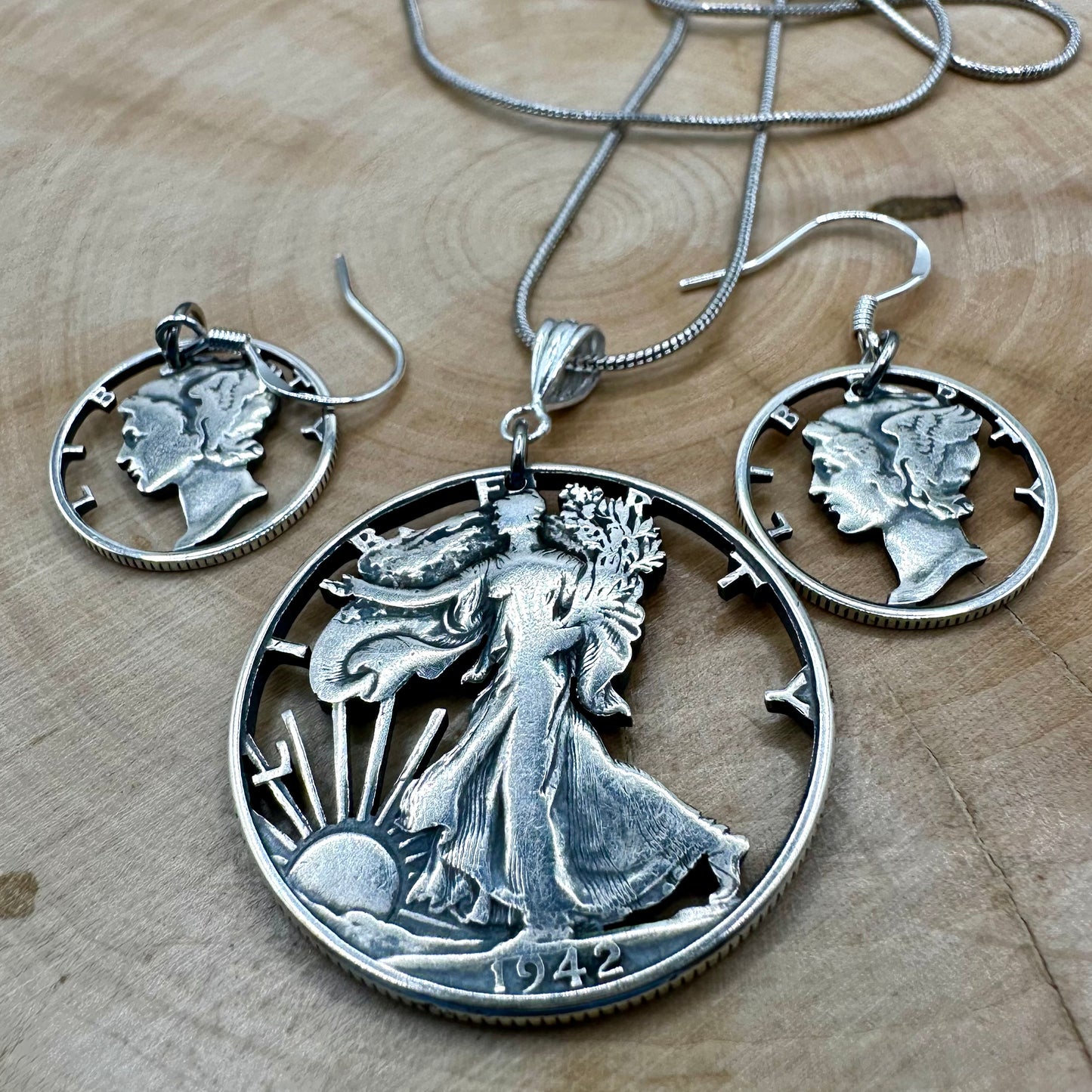 U.S. Lady Liberty Hand Cut Silver Coin Collection (snake chain) on a wood background- Mountainstruck Coin Jewelry