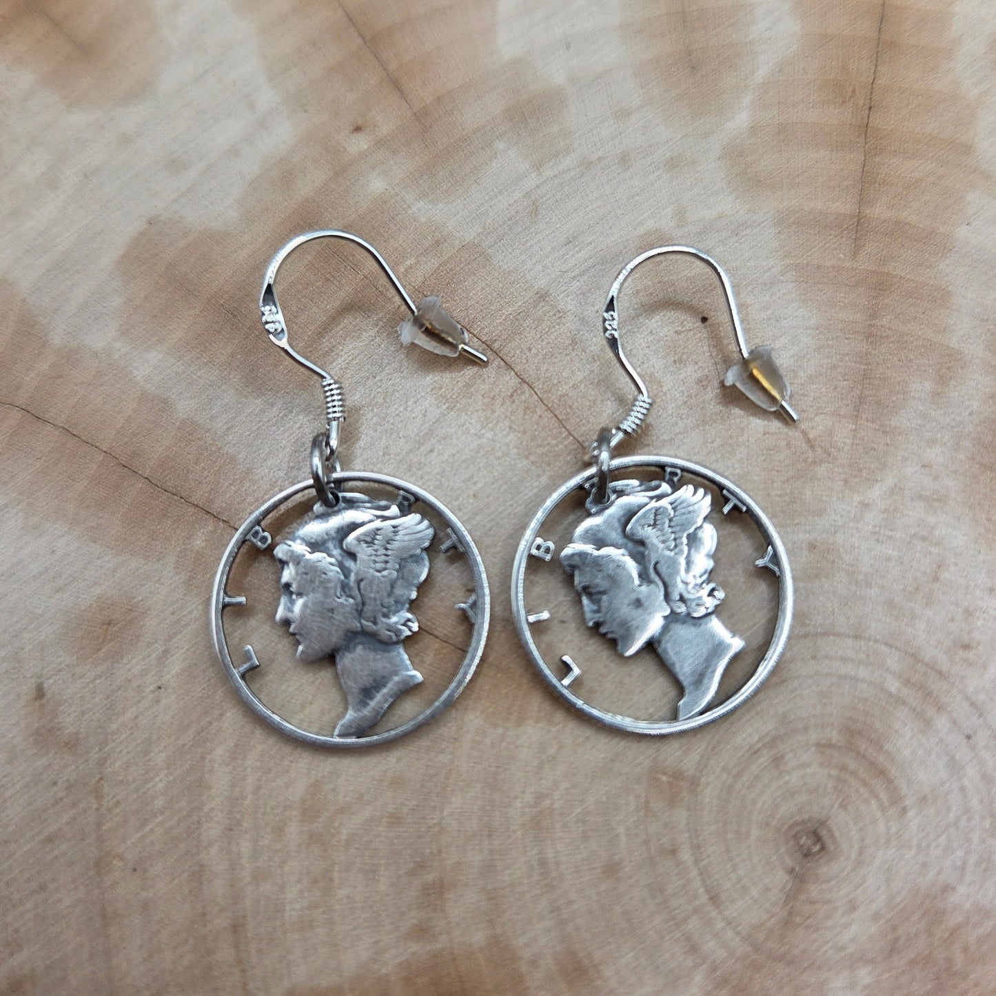 U.S. Lady Liberty Hand Cut Silver Coin Collection earrings on a wood background- Mountainstruck Coin Jewelry