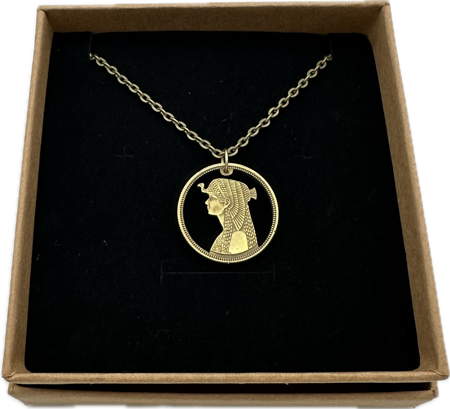 Cleopatra Egypt 50 Qirsh/Piastres Hand Cut Coin Necklace in a brown kraft box on a black velvet background. - Mountainstruck Coin Jewelry