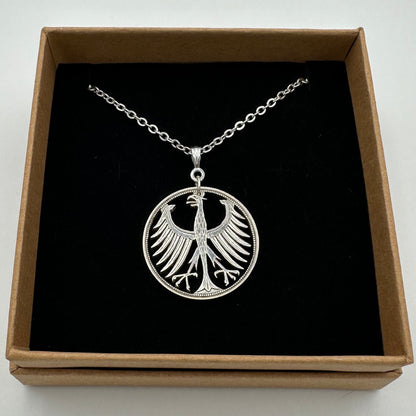 Germany Eagle 5 Mark Hand Cut Silver Coin Necklace in a brown kraft box on a black velvet background. - Mountainstruck Coin Jewelry