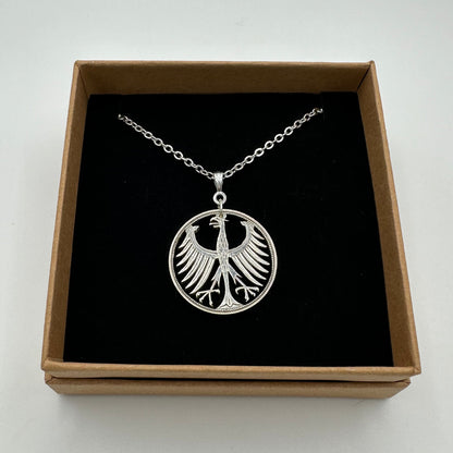 Germany Eagle 5 Mark Hand Cut Silver Coin Necklace in a brown kraft box on a black velvet background. - Mountainstruck Coin Jewelry
