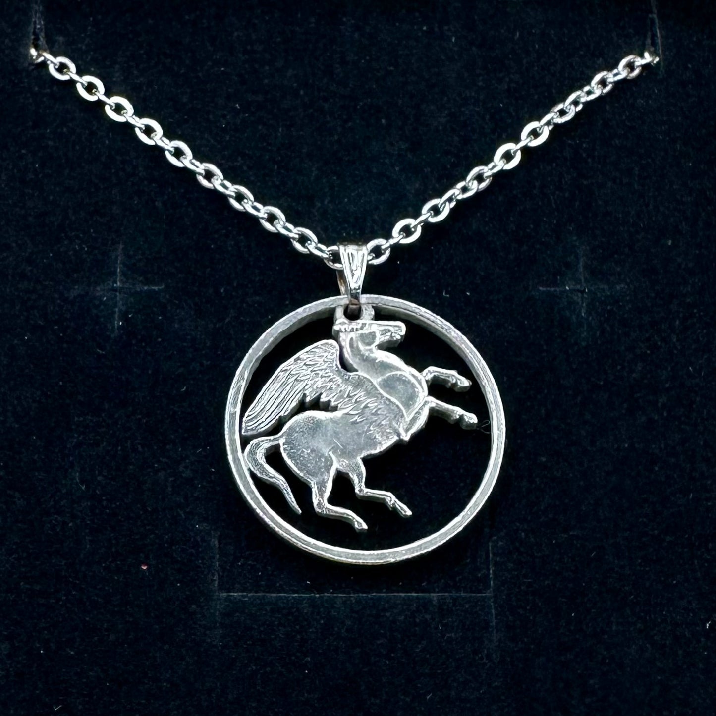 Greece Pegasus 5 Drachmai Hand Cut Coin Necklace with a stainless chain on a black velvet background. - Mountainstruck Coin Jewelry