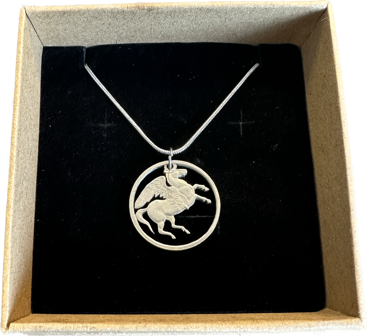 Greece Pegasus 5 Drachmai Hand Cut Coin Necklace with a snake chain in a brown kraft box on a black velvet background. - Mountainstruck Coin Jewelry