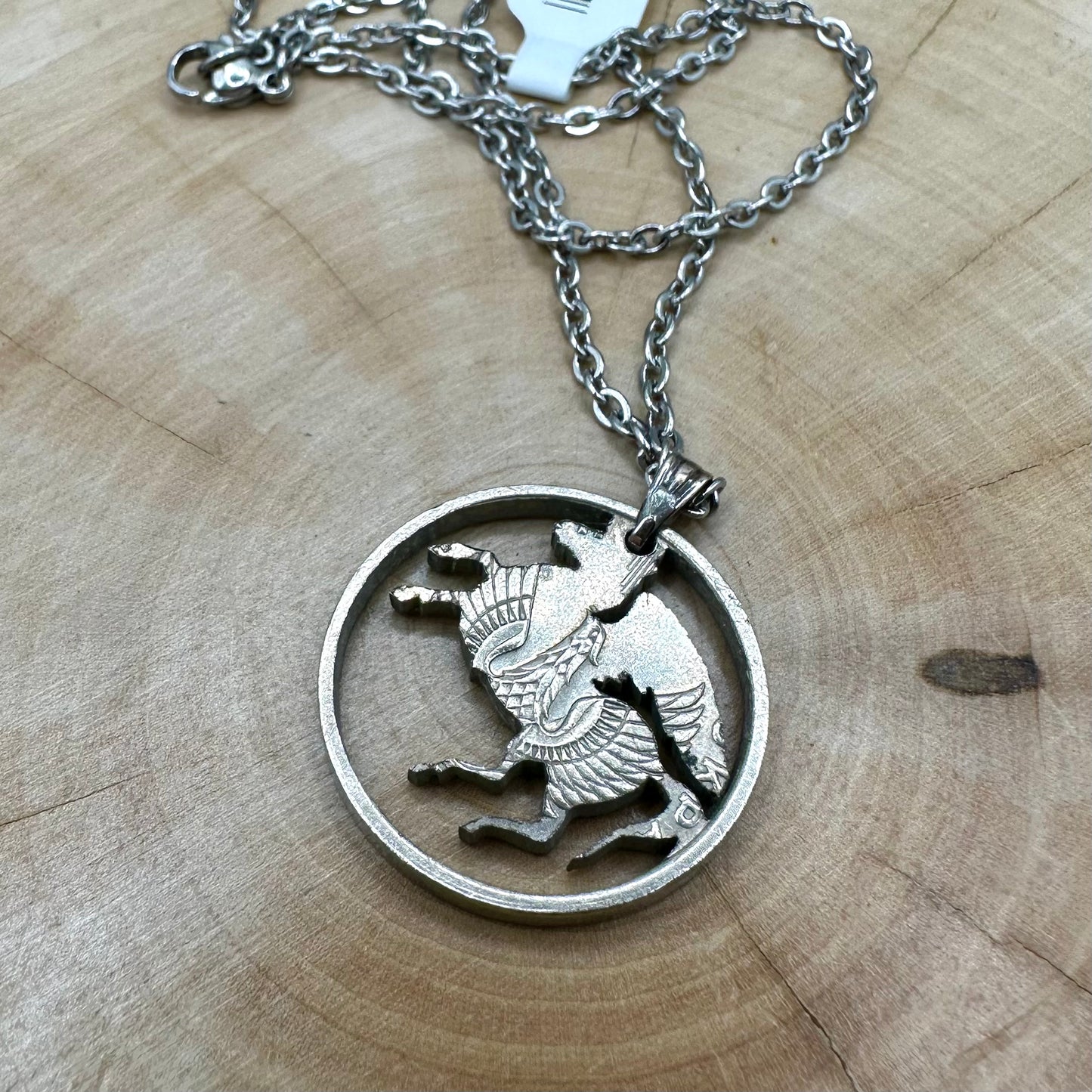Greece Pegasus 5 Drachmai Hand Cut Coin Necklace back with a stainless chain on a wood background. - Mountainstruck Coin Jewelry