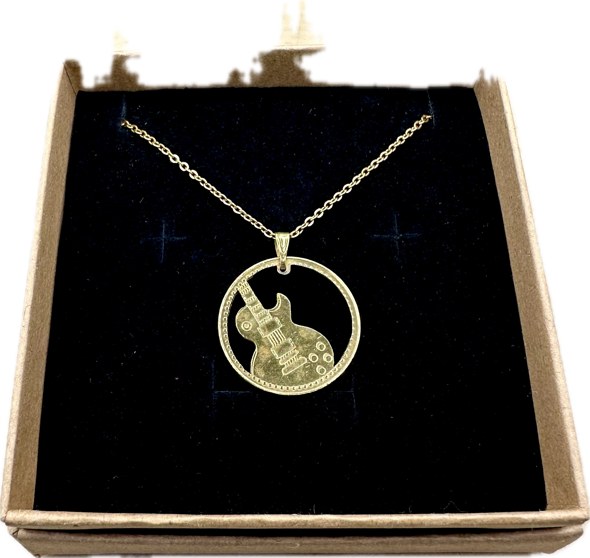 Guitar Hand Cut Token Necklace in a brown kraft box on a black velvet background. - Mountainstruck Coin Jewelry