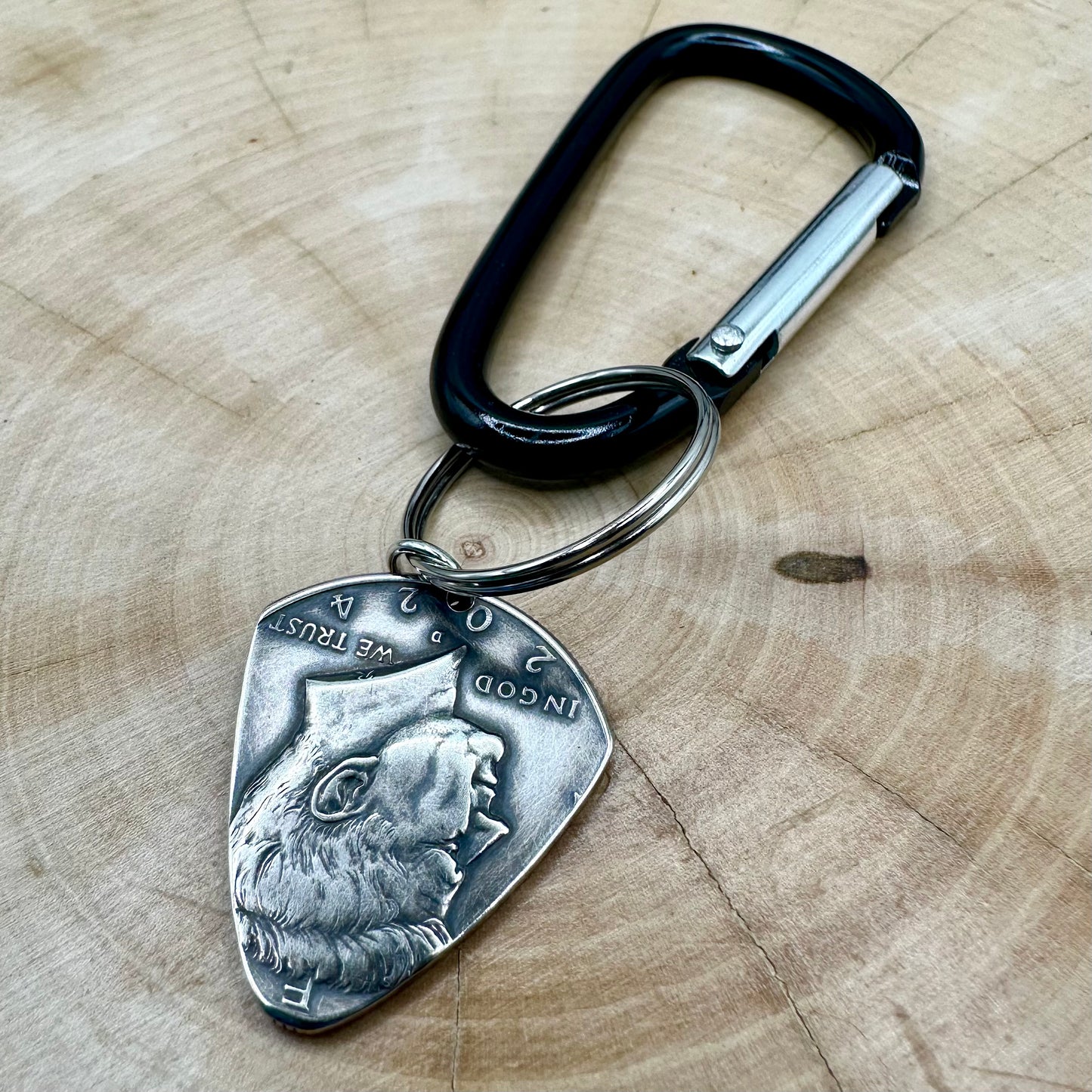 Guitar Pick U.S. Half Dollar Keychain back with a black carabiner on a light wood round. - Mountainstruck Coin Jewelry