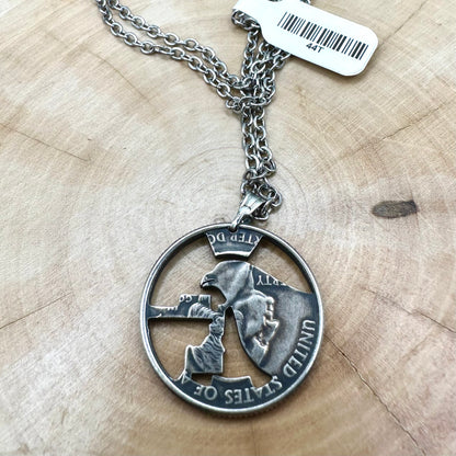 Idaho State Quarter Hand Cut Coin Necklace back with a stainless steel chain on a wood background. - Mountainstruck Coin Jewelry