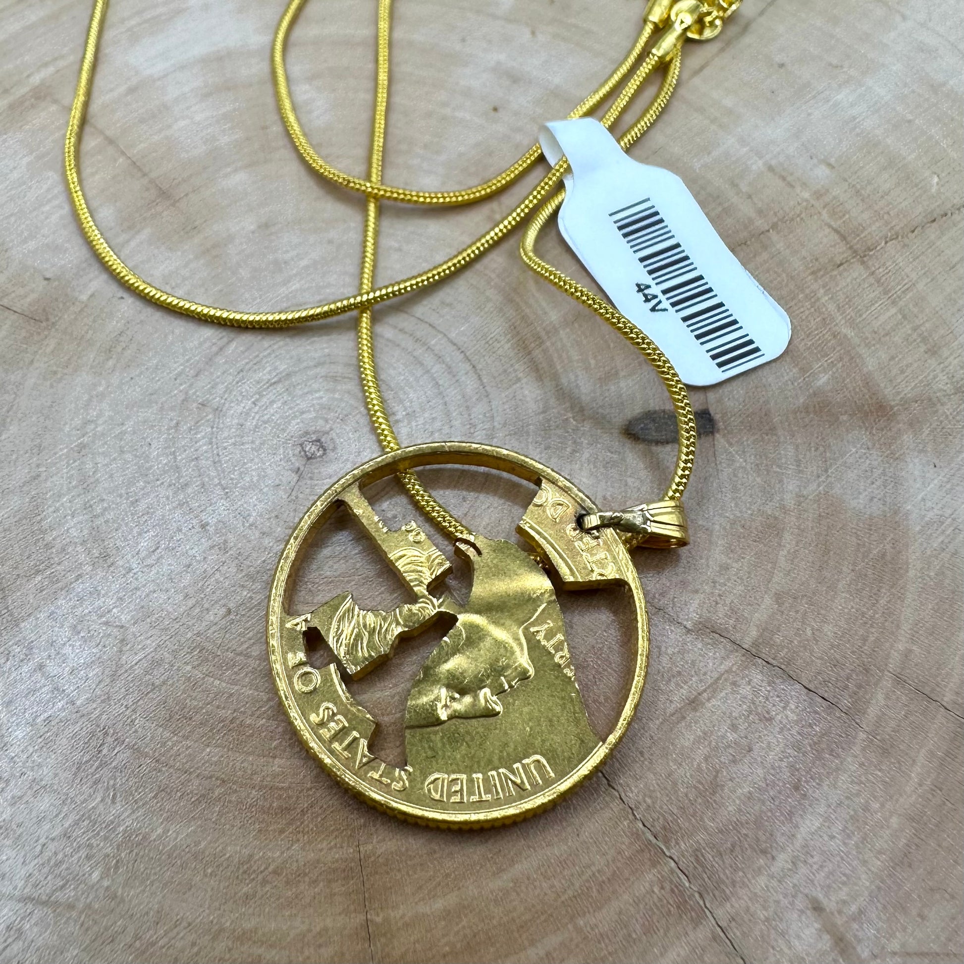 Idaho State Quarter Hand Cut Coin Necklace 24k gold plated back with a snake chain on a wood background. - Mountainstruck Coin Jewelry