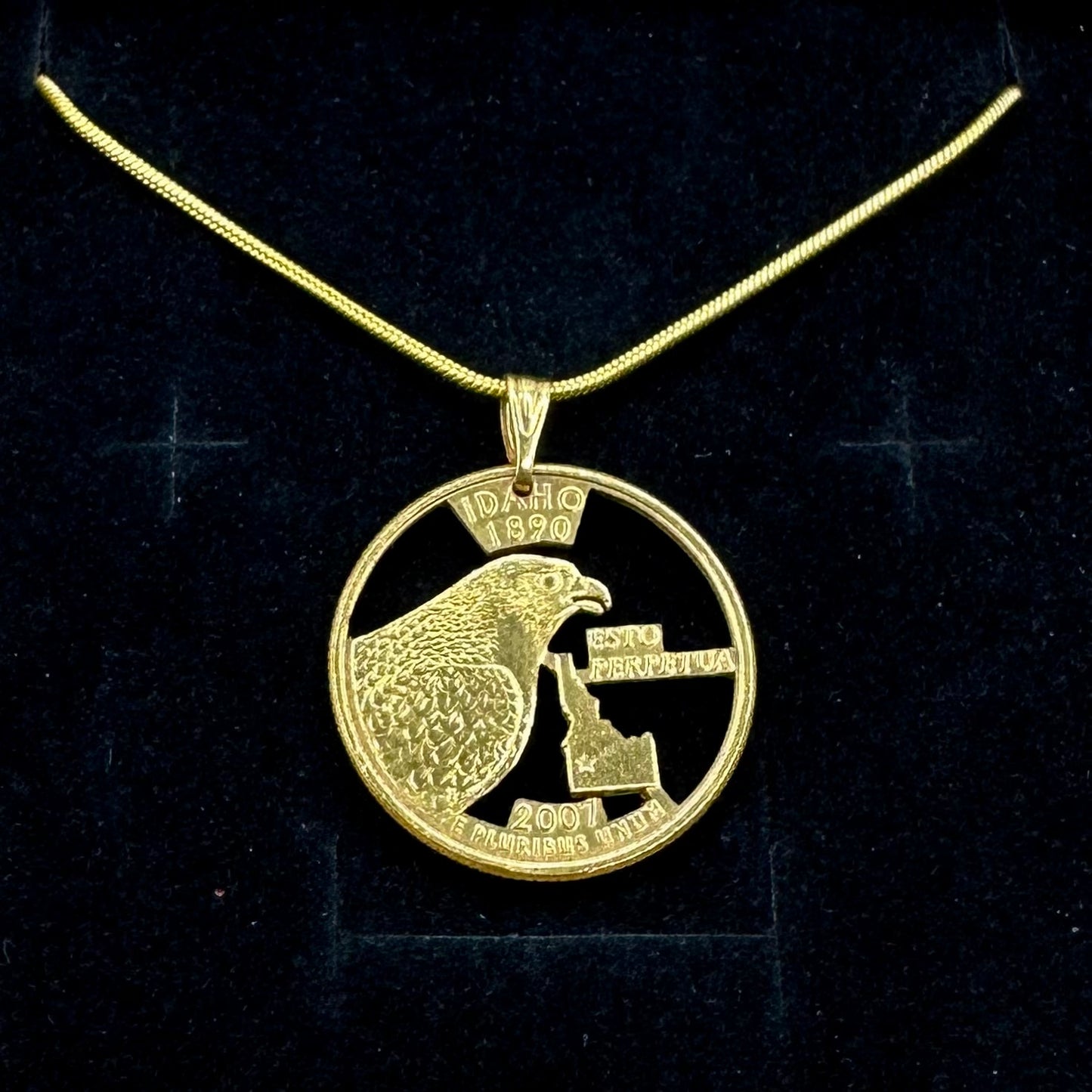 Idaho State Quarter Hand Cut Coin Necklace 24k gold plated with a snake chain on a black velvet background. - Mountainstruck Coin Jewelry