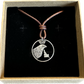 Idaho State Quarter Hand Cut Coin Necklace with a leather cord in a brown kraft box on a black velvet background. - Mountainstruck Coin Jewelry