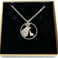 Idaho State Quarter Hand Cut Coin Necklace with a stainless chain in a brown kraft box on a black velvet background. - Mountainstruck Coin Jewelry