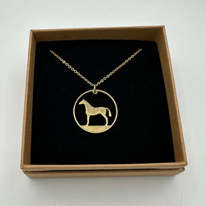 Ireland Horse 20 Pence Hand Cut Coin Necklace in a brown kraft box on a black velvet background. - Mountainstruck Coin Jewelry
