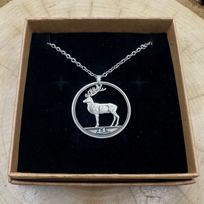 Ireland Red Deer Hand Cut Coin Necklace on a black velvet background in a brown kraft box on a wood round. - Mountainstruck Coin Jewelry
