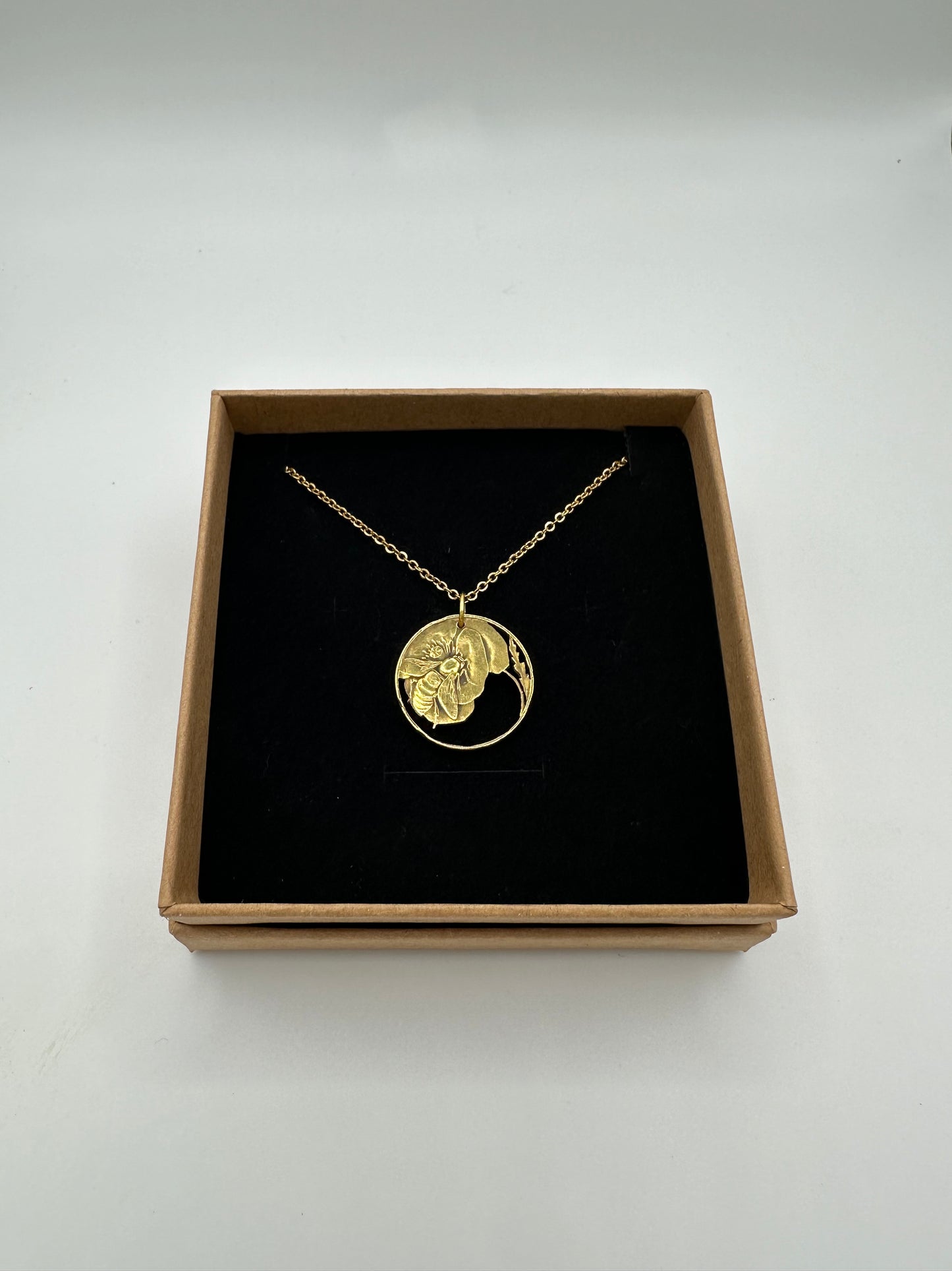 Italy Honeybee 10 Centesimi Hand Cut Coin Necklace in a brown kraft box on a black velvet background. - Mountainstruck Coin Jewelry