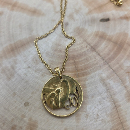 Honeybee Italy 10 Centesimi Hand Cut Coin Necklace on a wood background. - Mountainstruck Coin Jewelry