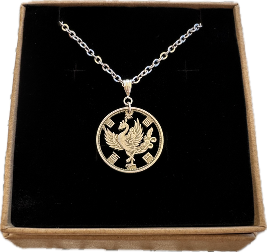 Phoenix Japan 100 Yen Silver Hand Cut Coin Necklace in a brown kraft box on a black velvet background. - Mountainstruck Coin Jewelry