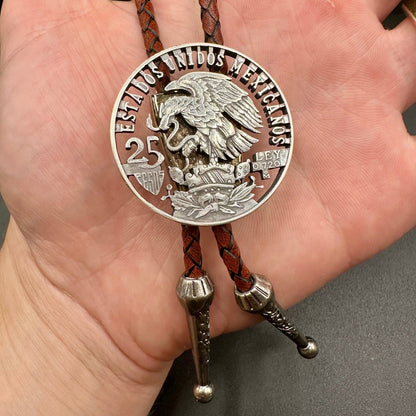 Mexico Silver 25 Pesos Hand Cut Coin Bolo Tie with darker brown leather cord on a hand for display. - Mountainstruck Coin Jewelry
