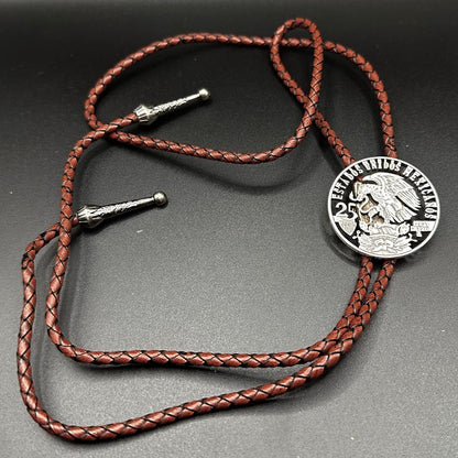Mexico Silver 25 Pesos Hand Cut Coin Bolo Tie with darker brown leather cord on black background. - Mountainstruck Coin Jewelry
