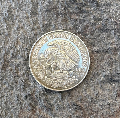 Mexico Silver 25 Pesos coin back on a grey rock surface. - Mountainstruck Coin Jewelry