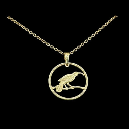New Zealand Huia Bird 6 Pence Silver 24k Gold Plated Hand Cut Coin Necklace on a black velvet background. - Mountainstruck Coin Jewelry