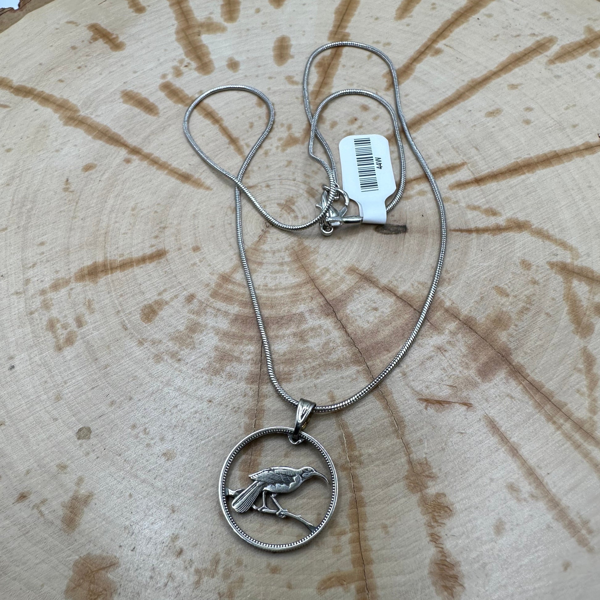 Huia Bird Silver New Zealand 6 Pence Hand Cut Coin Necklace on a black velvet background. - Mountainstruck Coin Jewelry
