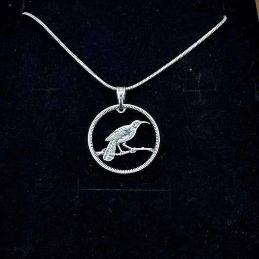Huia Bird Silver New Zealand 6 Pence Hand Cut Coin Necklace on a black velvet background. - Mountainstruck Coin Jewelry
