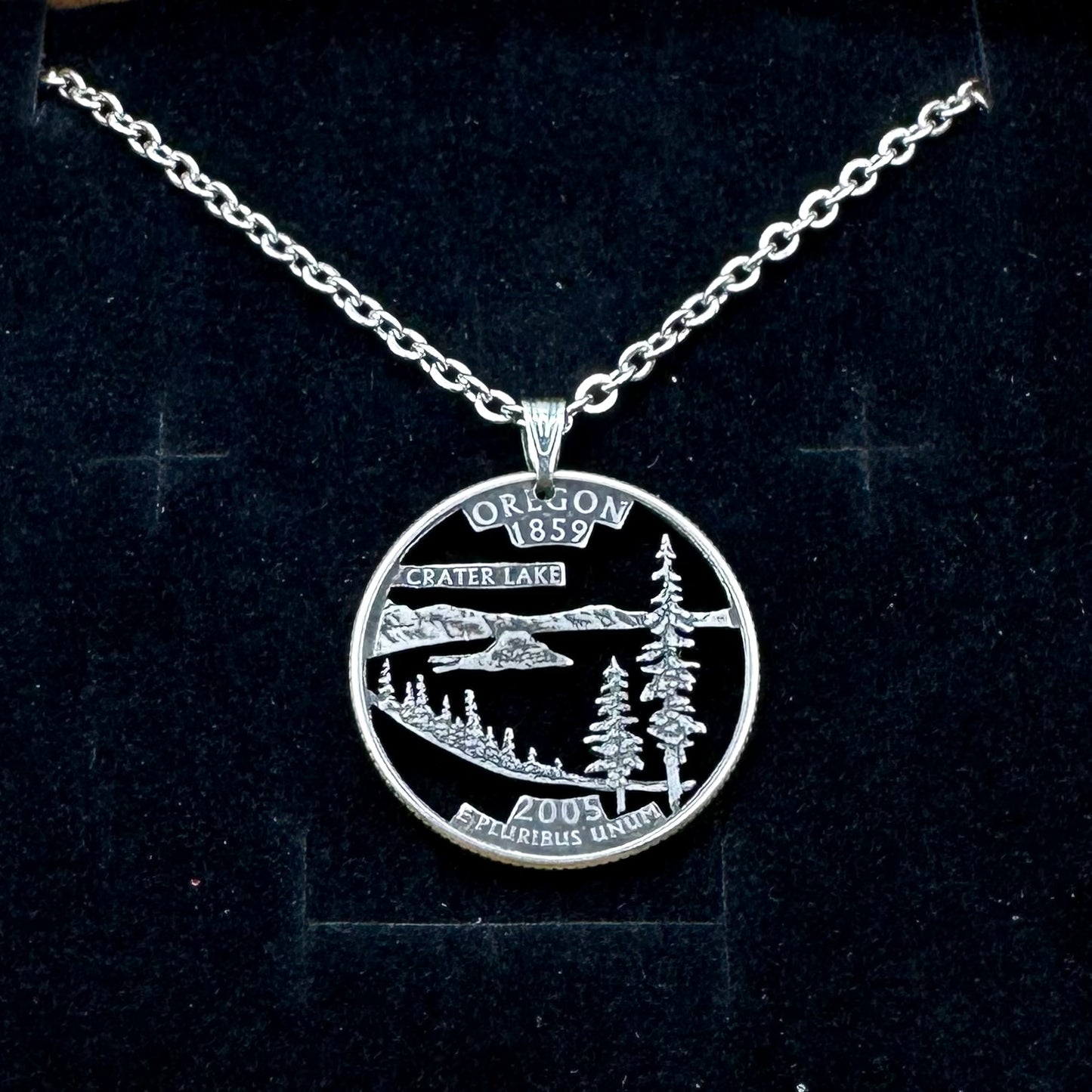 Oregon State Quarter Hand Cut Coin Necklace with a stainless chain on a black velvet background. - Mountainstruck Coin Jewelry