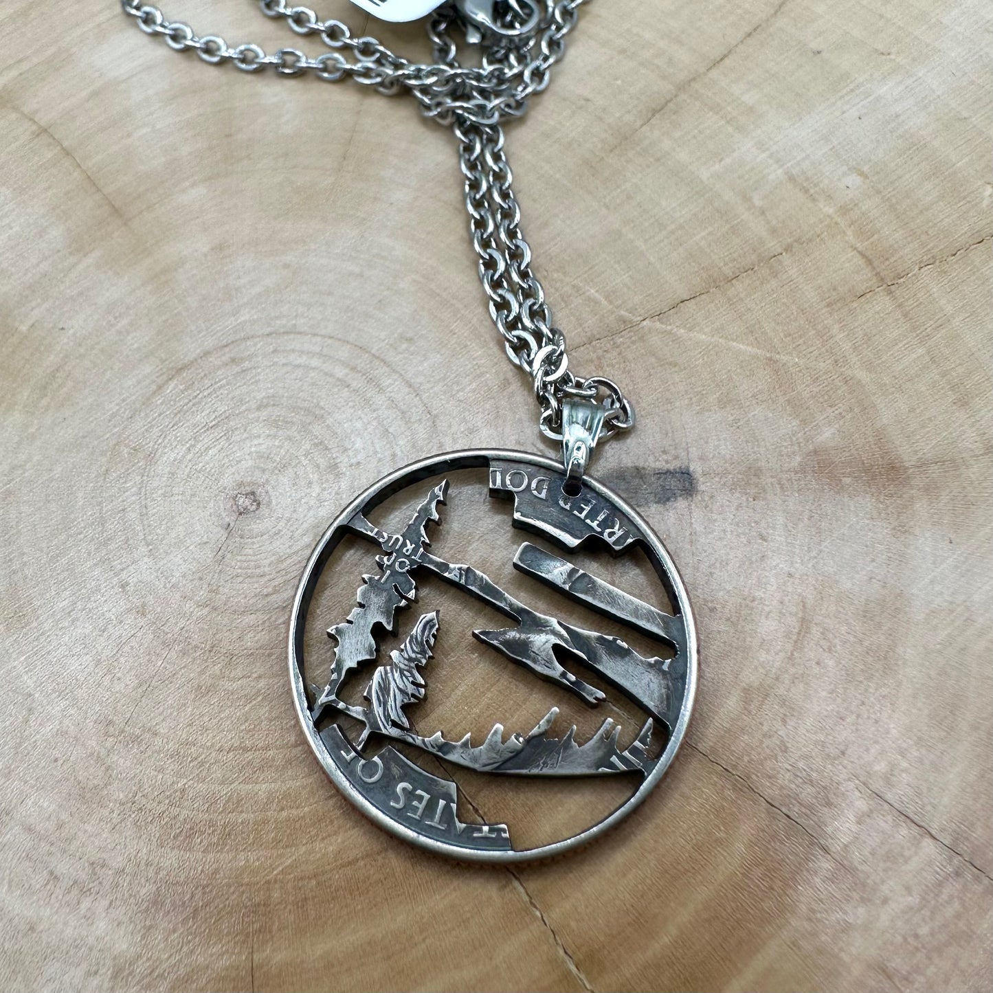 Oregon State Quarter Hand Cut Coin Necklace back with a stainless steel chain on a wood background. - Mountainstruck Coin Jewelry