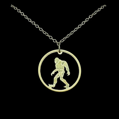 Sasquatch Hand Cut Token Necklace with a bronze chain on a black velvet background. - Mountainstruck Coin Jewelry