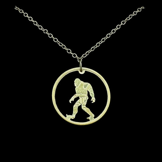Sasquatch Hand Cut Token Necklace with a bronze chain on a black velvet background. - Mountainstruck Coin Jewelry