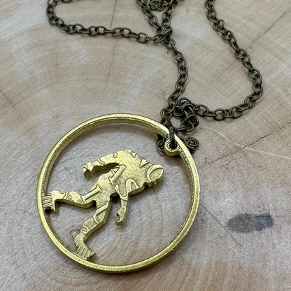 Sasquatch Hand Cut Token Necklace back with a bronze chain on a light wood background. - Mountainstruck Coin Jewelry