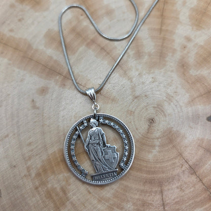 Swiss Lady 1 Franc Silver Hand Cut Coin Necklace on a wood background. - Mountainstruck Coin Jewelry