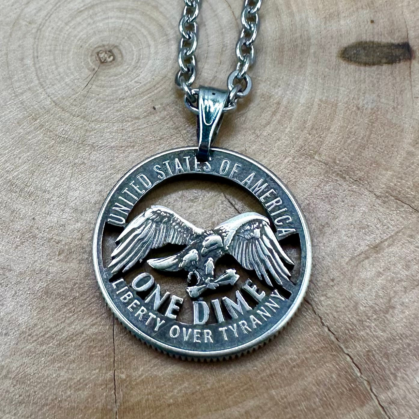 U.S. 2026 "Eagle" Dime Hand Cut Coin Necklace on a wood background. - Mountainstruck Coin Jewelry