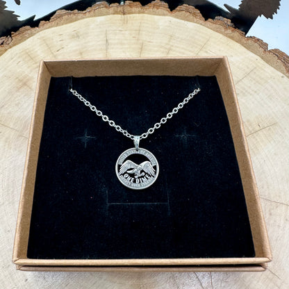 U.S. 2026 "Eagle" Dime Hand Cut Coin Necklace on a black velvet background in a brown kraft box on a wood round. - Mountainstruck Coin Jewelry