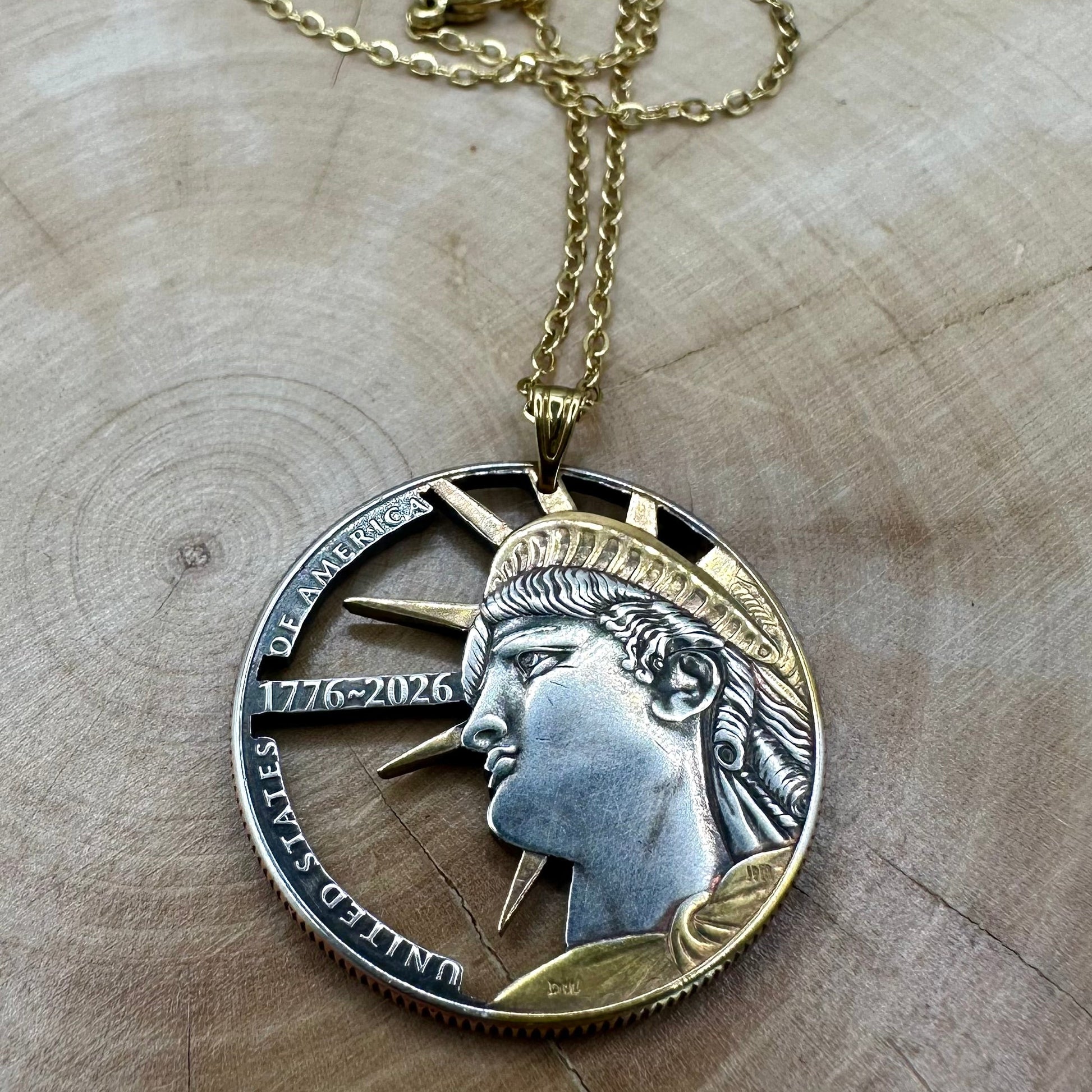 U.S. Half Dollar Hand Cut Coin Necklace (front) 24k gold plated with a gold plated chain on a light wood round. - Mountainstruck Coin Jewelry