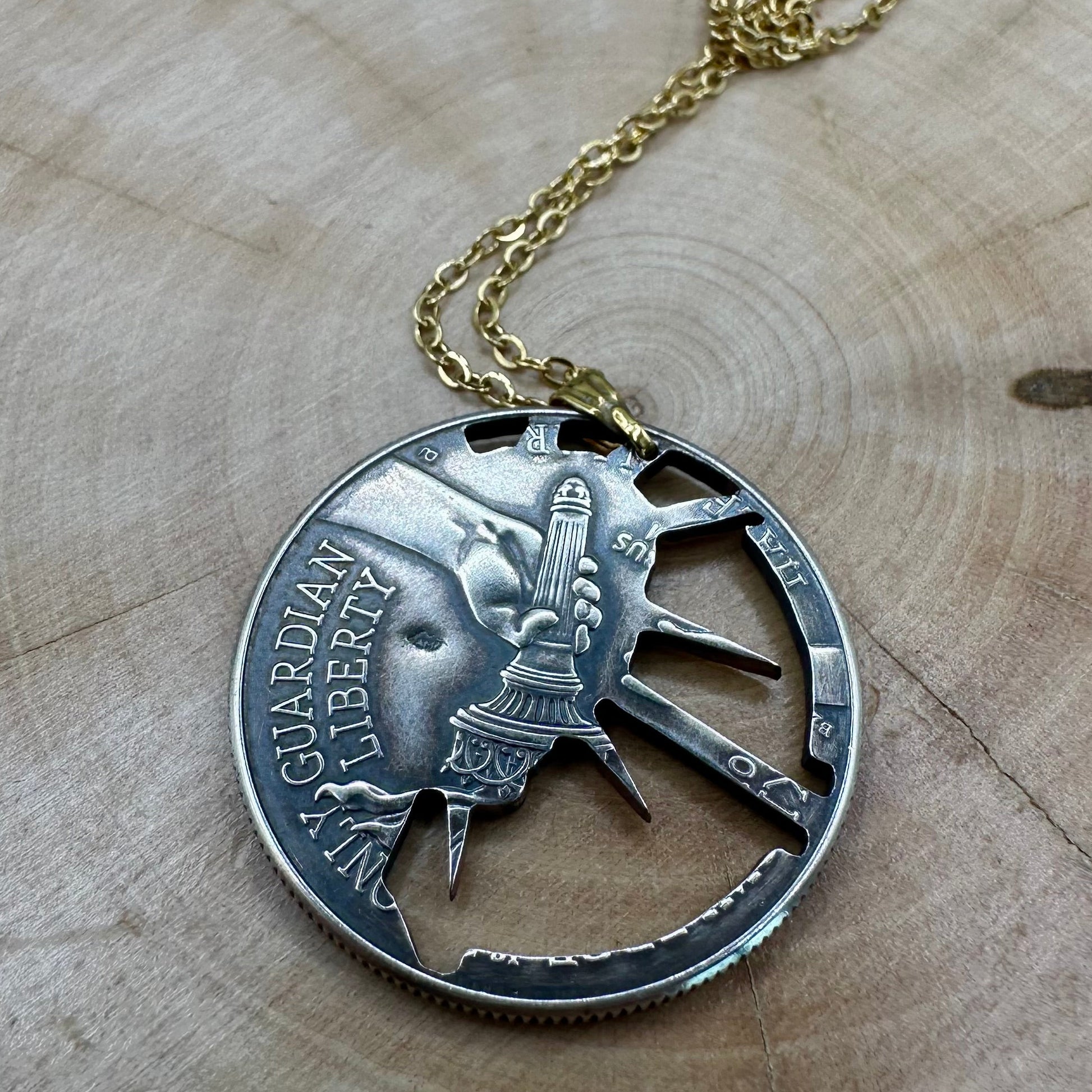U.S. Half Dollar Hand Cut Coin Necklace (front) 24k gold plated with a gold plated chain on a light wood round. - Mountainstruck Coin Jewelry