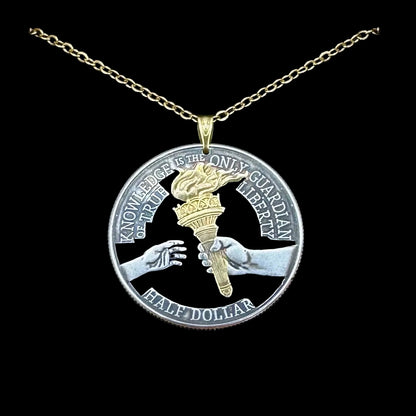 U.S. 2026 Half Dollar Hand Cut Coin Necklace (reverse) 24k Gold Plated Torch with a gold plated chain on a black velvet background. - Mountainstruck Coin Jewelry
