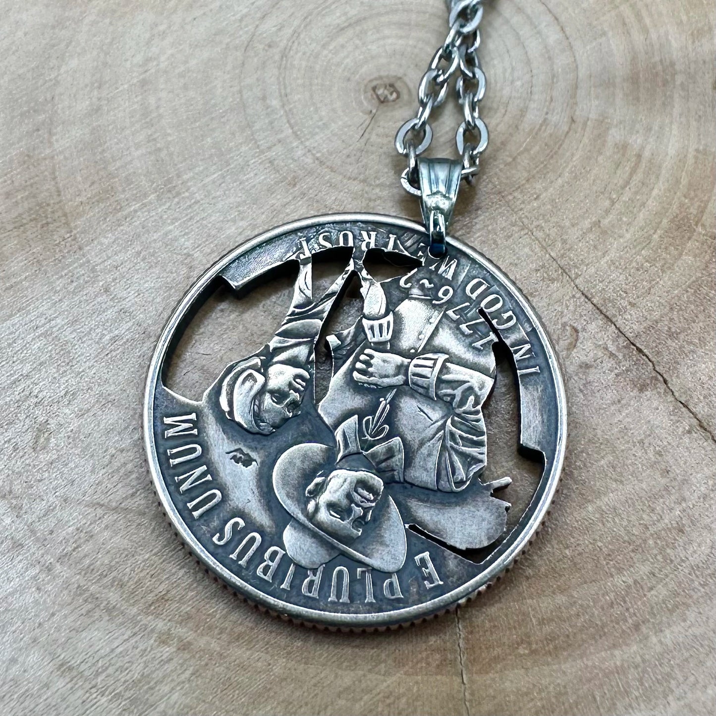 U.S. 2026 "Mayflower" Quarter Hand Cut Coin Necklace back with a stainless chain on a wood background. - Mountainstruck Coin Jewelry