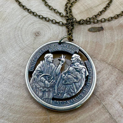 U.S. 2026 Oneida Allies 1 Dollar Hand Cut Coin Necklace with a bronze chain on a wood background. - Mountainstruck Coin Jewelry 